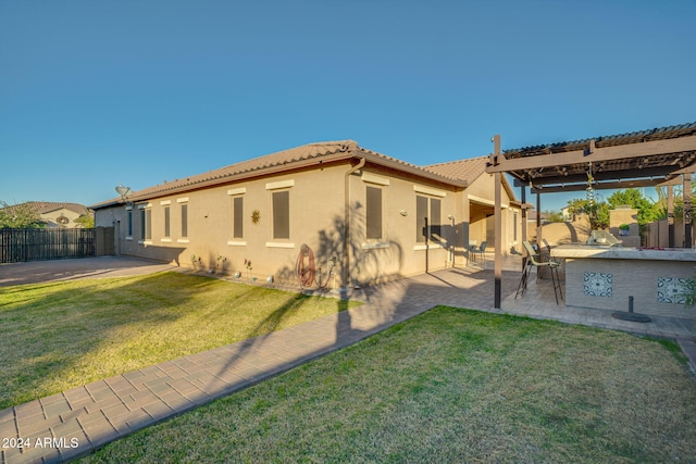 rear view of house featuring a lawn and a patio area