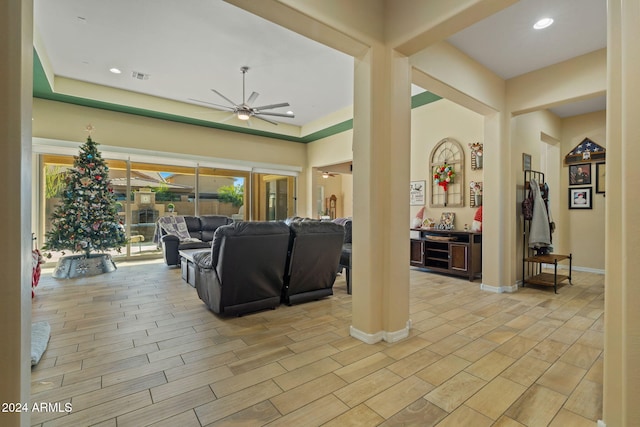 living room featuring a tray ceiling and ceiling fan