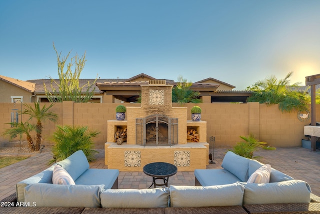 patio terrace at dusk featuring an outdoor living space with a fireplace