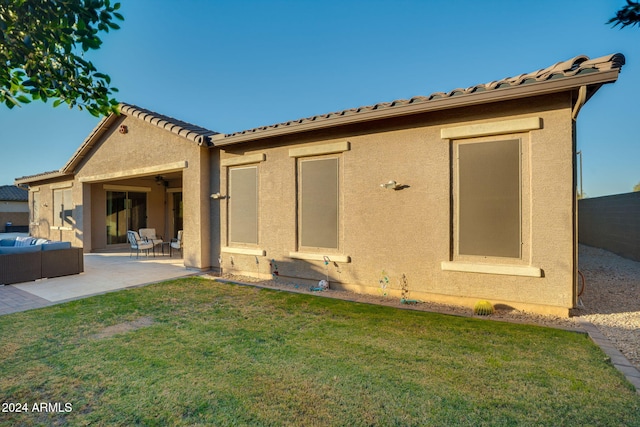 rear view of property featuring a lawn and a patio