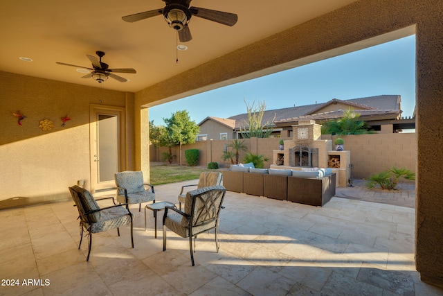 view of patio / terrace with an outdoor living space with a fireplace and ceiling fan