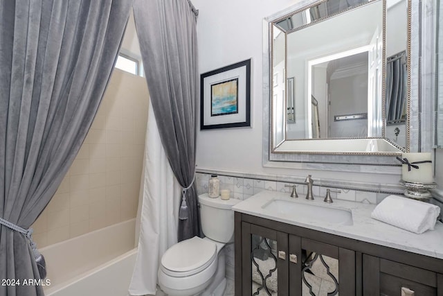 full bathroom with tile walls, shower / tub combo with curtain, vanity, and toilet