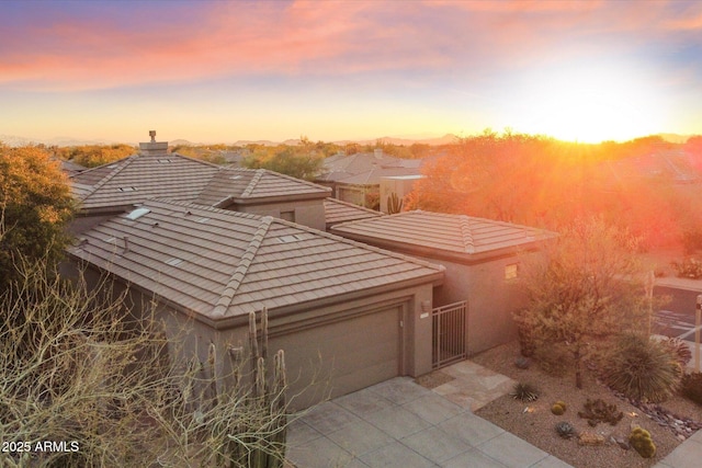 view of front facade with a tile roof, stucco siding, and driveway