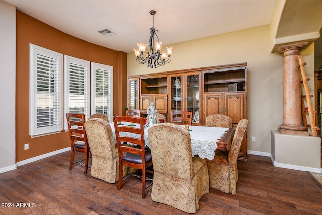 dining space featuring ornate columns, an inviting chandelier, and dark hardwood / wood-style flooring