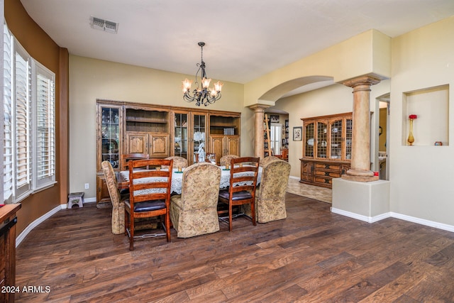 dining area with ornate columns, dark hardwood / wood-style flooring, and a notable chandelier