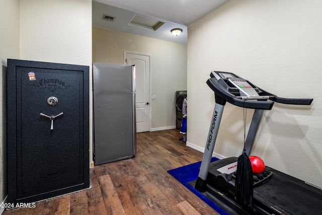 workout area with dark hardwood / wood-style floors and washer / dryer