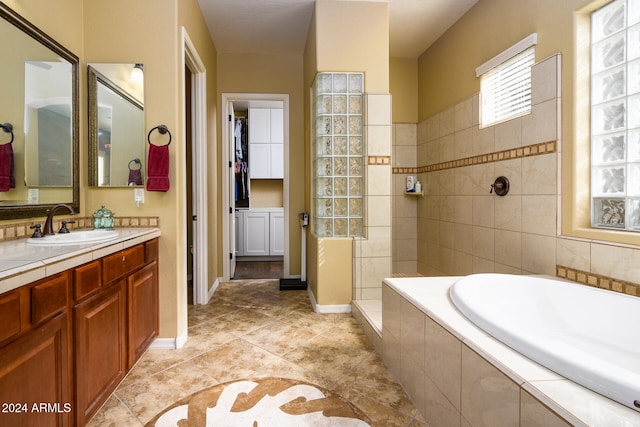 bathroom featuring independent shower and bath, tile patterned flooring, and vanity