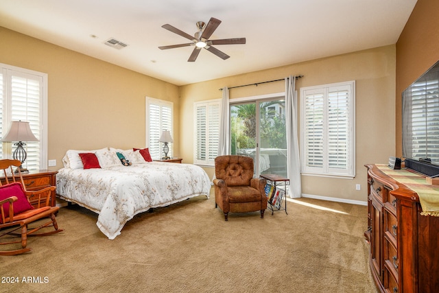 bedroom with light colored carpet, ceiling fan, and access to exterior