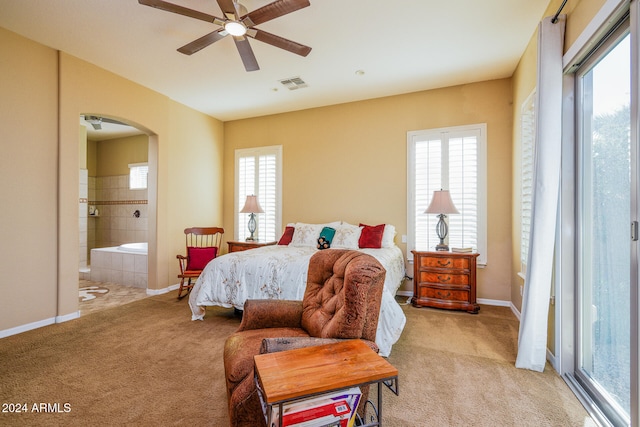 carpeted bedroom featuring access to exterior, ensuite bath, multiple windows, and ceiling fan