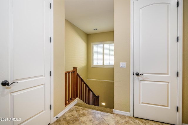 stairway with tile patterned floors