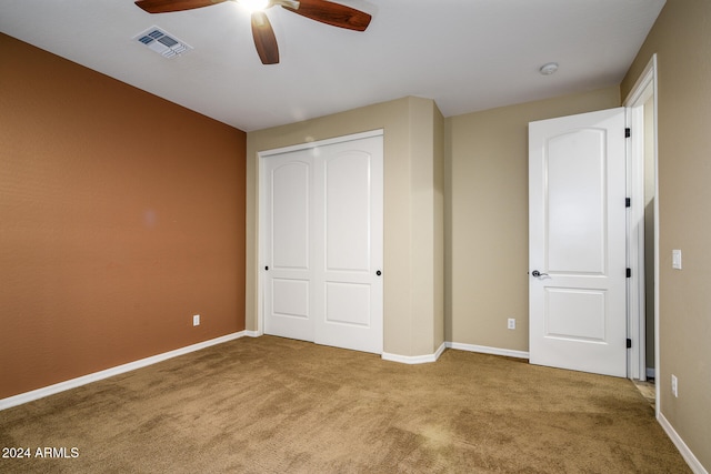 unfurnished bedroom with ceiling fan, a closet, and carpet