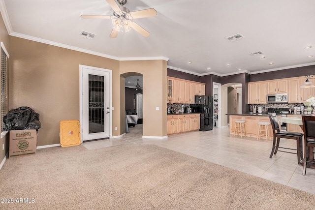 10529 E Posada Ave, Mesa, AZ 85212 - kitchen with arched walkways, stainless steel microwave, black refrigerator with ice dispenser, a ceiling fan, and ornamental molding