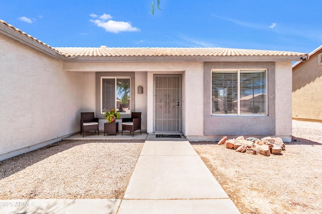 1858 S Ocotillo Dr, Apache Junction, AZ 85120 - doorway to property featuring stucco siding, a tiled roof, and a patio area
