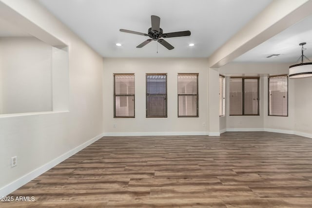 unfurnished room with ceiling fan and dark wood-type flooring