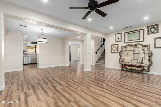 unfurnished living room featuring ceiling fan and light wood-type flooring