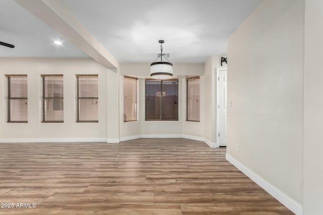 empty room with ceiling fan and light hardwood / wood-style floors