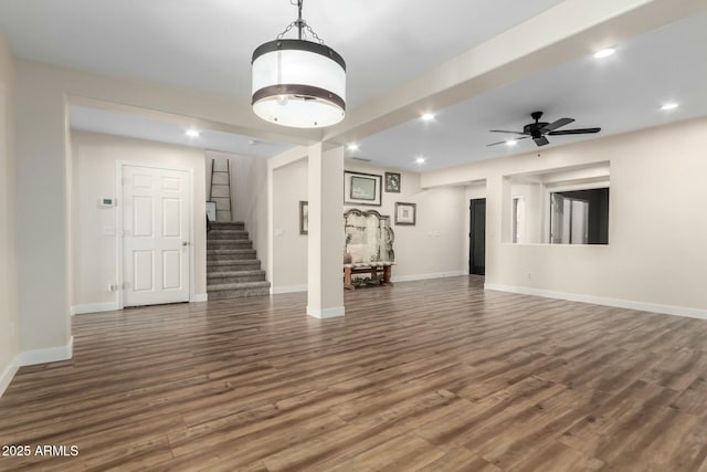 unfurnished living room featuring ceiling fan and dark hardwood / wood-style floors