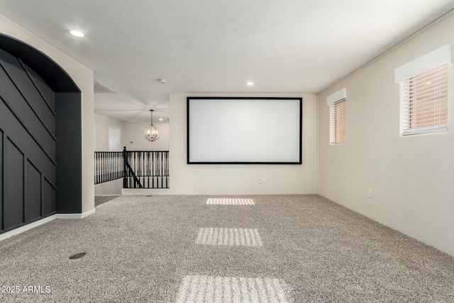 cinema featuring an inviting chandelier and carpet flooring