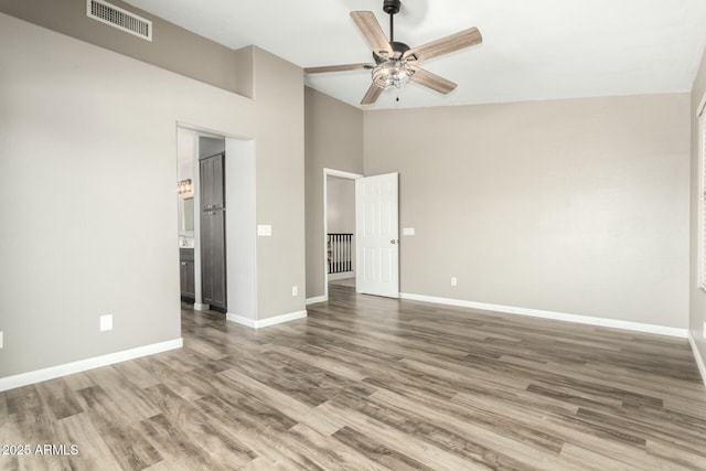 interior space with a high ceiling, ceiling fan, and hardwood / wood-style floors