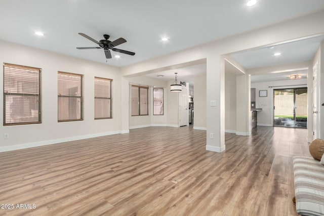 unfurnished living room featuring ceiling fan and light hardwood / wood-style flooring