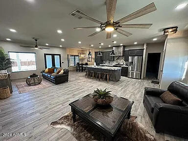 living room with ceiling fan and light hardwood / wood-style flooring