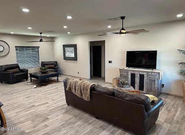 living room featuring ceiling fan and light hardwood / wood-style flooring