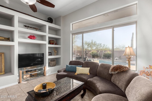 tiled living room with ceiling fan and built in features