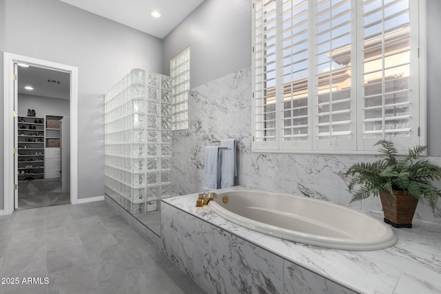 bathroom featuring shower with separate bathtub