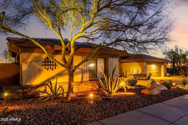 property exterior at dusk featuring a garage