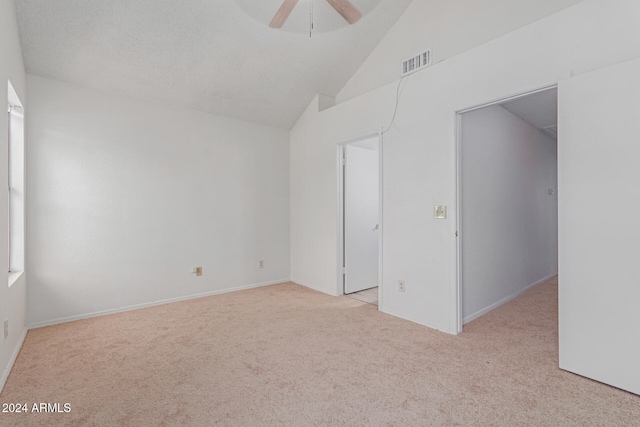 carpeted empty room with ceiling fan and lofted ceiling