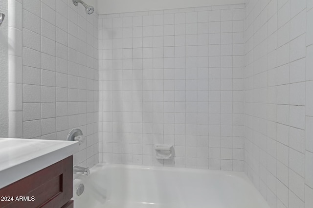 bathroom featuring vanity and tiled shower / bath