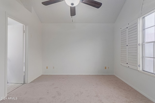 empty room with ceiling fan, light colored carpet, and lofted ceiling