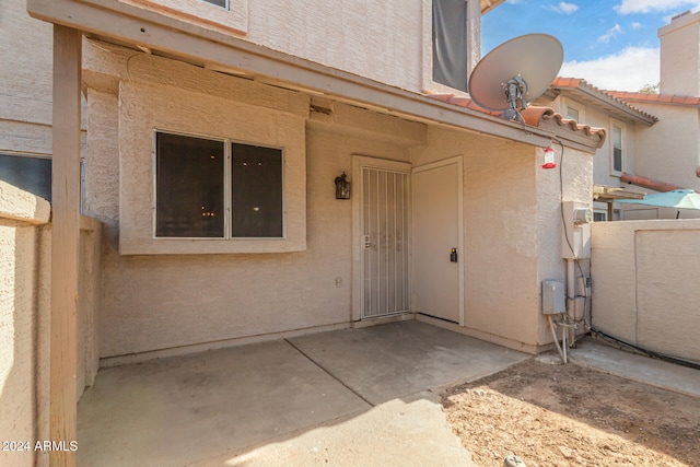 view of exterior entry with a patio area