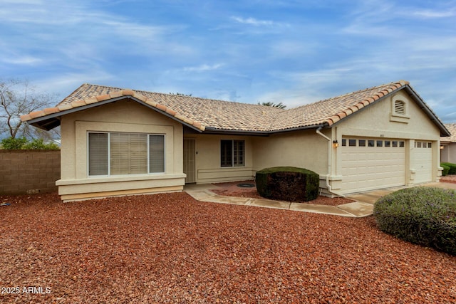 single story home with a tile roof, an attached garage, fence, and stucco siding