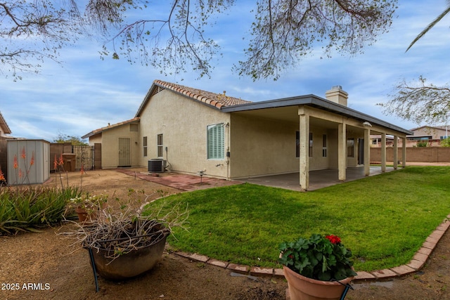 rear view of house featuring a patio area, stucco siding, central AC, and fence