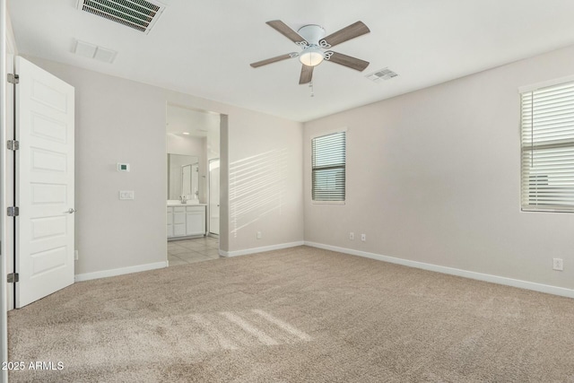 unfurnished room with sink, light colored carpet, and ceiling fan