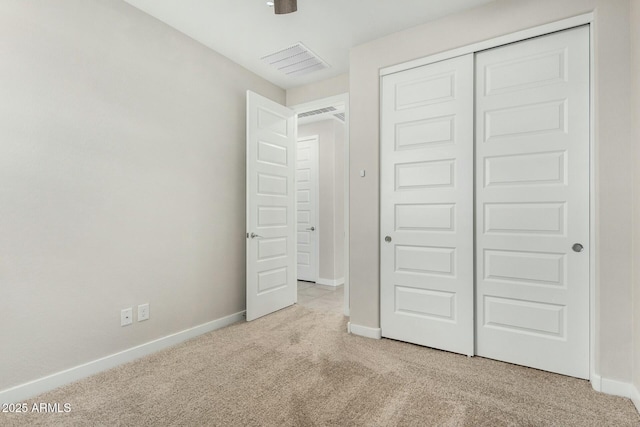 unfurnished bedroom with light carpet and a closet