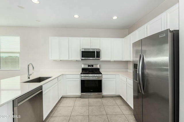 kitchen featuring light tile patterned floors, stainless steel appliances, sink, and white cabinets