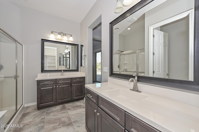 bathroom with a shower with shower door and vanity