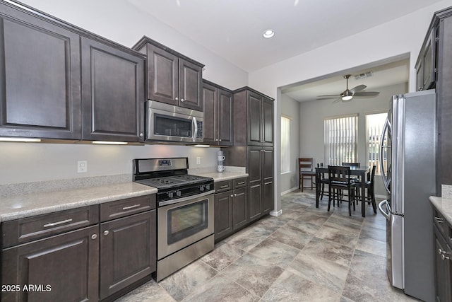 kitchen with stainless steel appliances, dark brown cabinetry, and ceiling fan