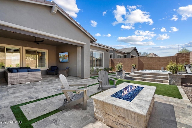 view of patio / terrace with fence, an outdoor living space with a fire pit, and ceiling fan