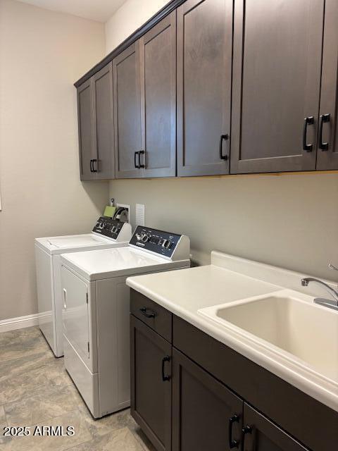 clothes washing area with a sink, independent washer and dryer, baseboards, and cabinet space