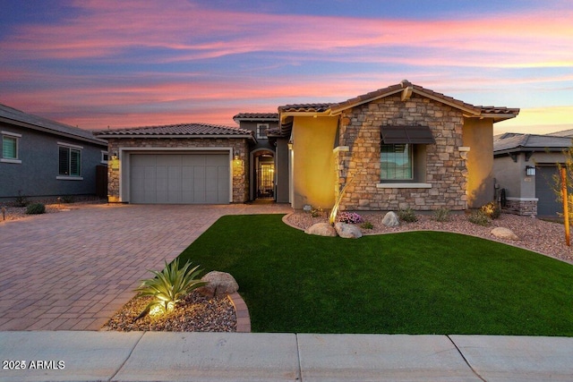 view of front of home featuring a garage, stucco siding, stone siding, and a tile roof