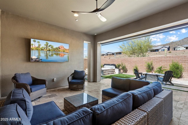 living area featuring a water view, stone tile floors, and a ceiling fan