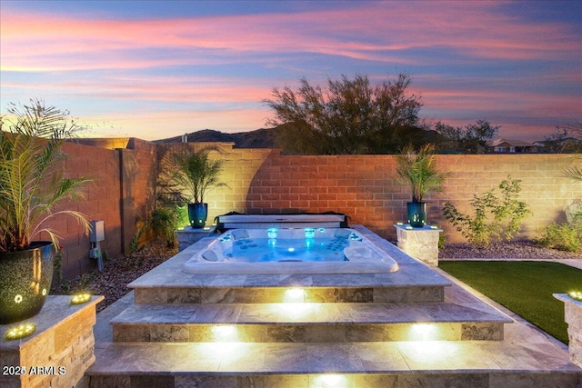 view of swimming pool featuring an outdoor hot tub and a fenced backyard