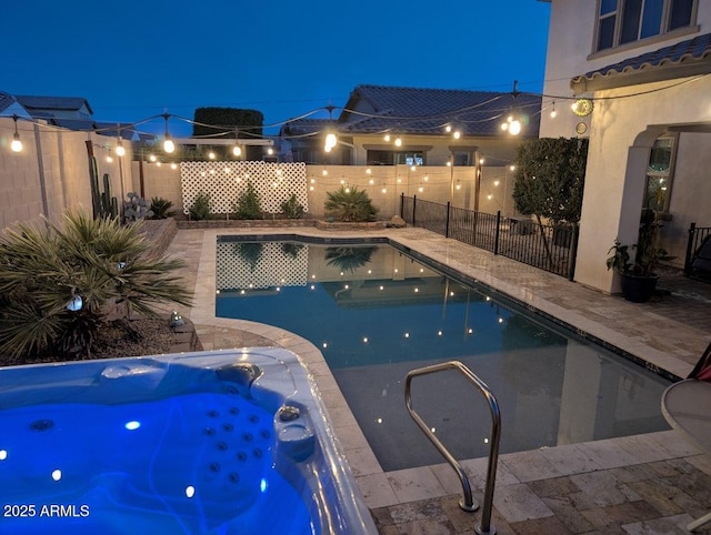 pool at night with an in ground hot tub