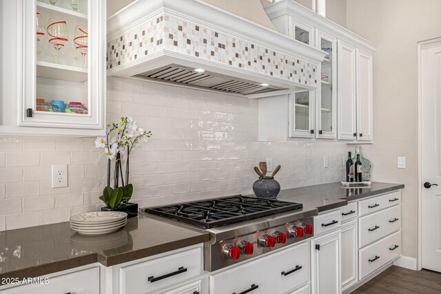 6328 W Fetlock Trl, Phoenix, AZ 85083 - kitchen featuring glass insert cabinets, stainless steel gas cooktop, decorative backsplash, custom exhaust hood, and white cabinetry