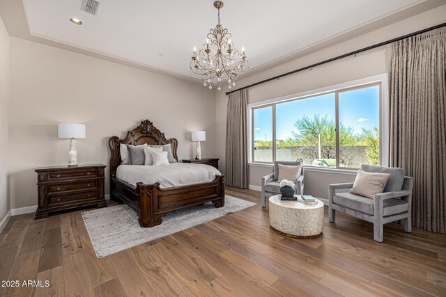 6328 W Fetlock Trl, Phoenix, AZ 85083 - bedroom featuring baseboards, visible vents, wood-type flooring, and a chandelier