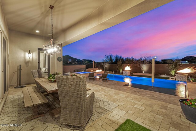 6328 W Fetlock Trl, Phoenix, AZ 85083 - patio terrace at dusk featuring outdoor dining area, a fenced backyard, and a fenced in pool