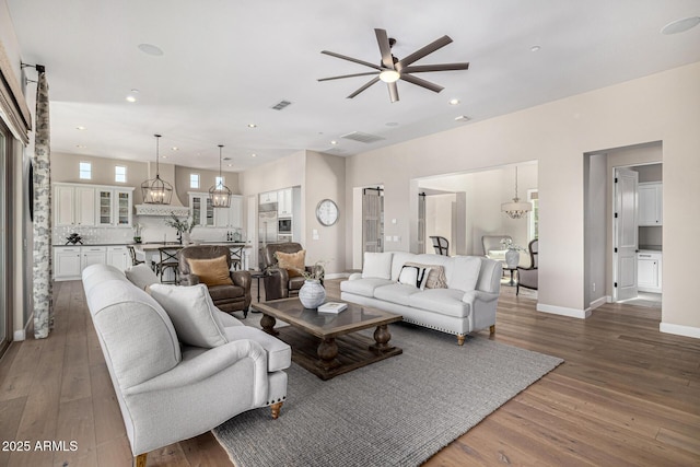 6328 W Fetlock Trl, Phoenix, AZ 85083 - living area with hardwood / wood-style floors, visible vents, baseboards, recessed lighting, and ceiling fan with notable chandelier